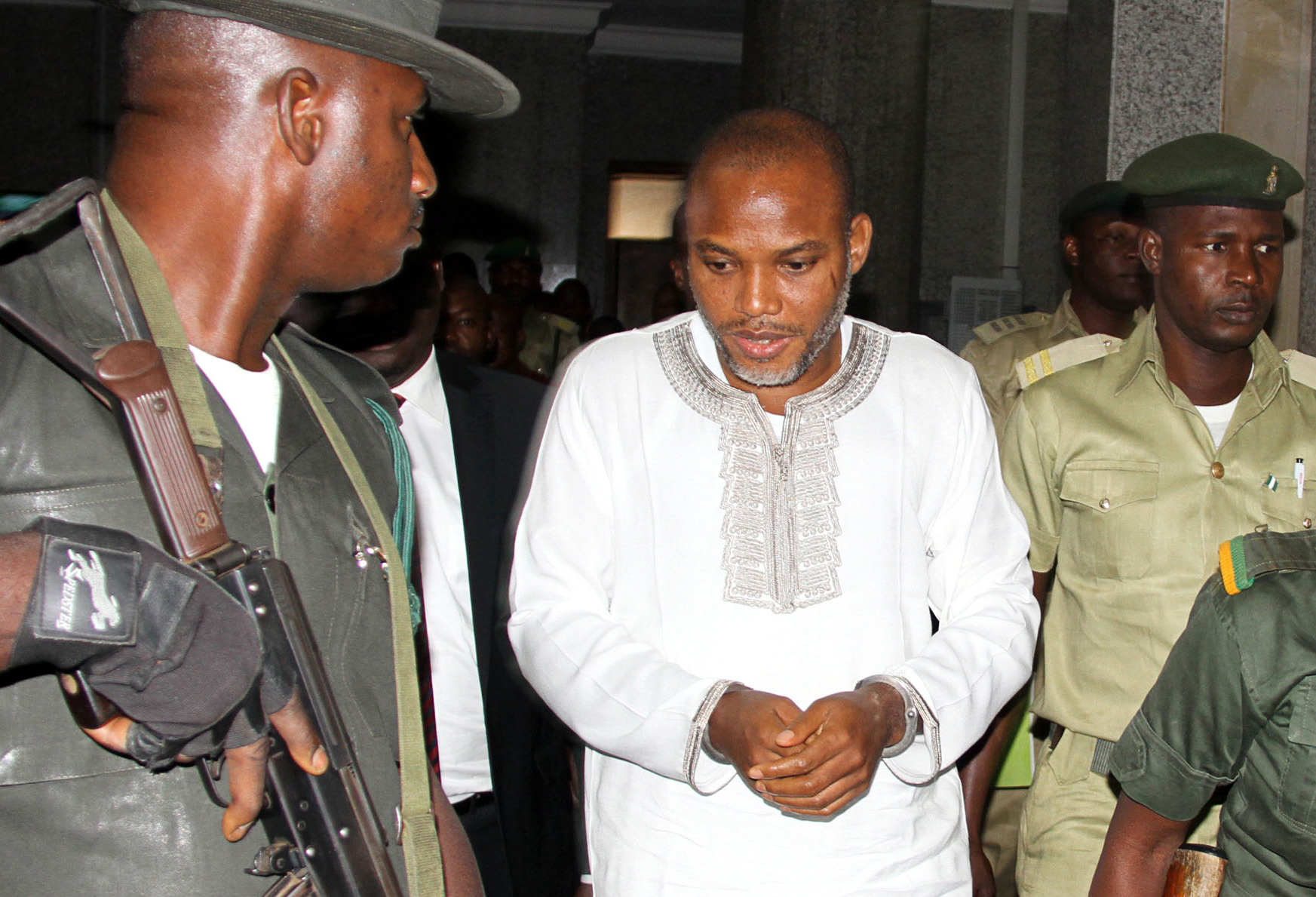 Leader of Indigenous Peoples of Biafra (IPOB), Nnamdi Kanu (C) attends a trial for treasonable felony at the Federal High court in Abuja, on February 9, 2016. Nnamdi Kanu, is accused by the state of "propagating a secessionist agenda" with the intention to "levy war against Nigeria". Kanu, who also runs the London-based Radio Biafra, is facing charges of treasonable felony, managing an unlawful society and illegally shipping radio equipment into the country. He has been in custody since his arrest in October 2015, despite being granted bail, and denied all charges.  / AFP / Pius Utomi EKPEI        (Photo credit should read PIUS UTOMI EKPEI/AFP/Getty Images)
